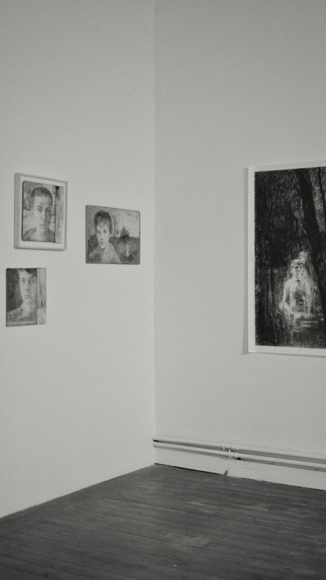 Black and white portrait photographs displayed on a gallery wall