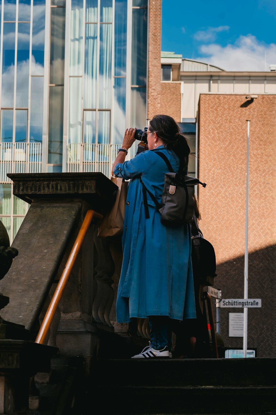 Photographer crouching to take a photo on a Chilean city street, seen from behind
